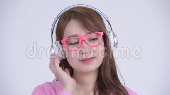 年轻快乐的亚洲书呆子女人听音乐的脸视频的预览图