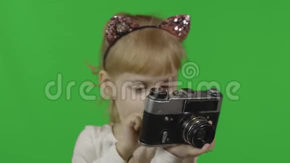 穿着猫头巾的女孩在旧的复古相机上拍照色度键视频的预览图