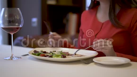 可爱的红衣女郎坐在餐厅吃美味的沙拉视频的预览图