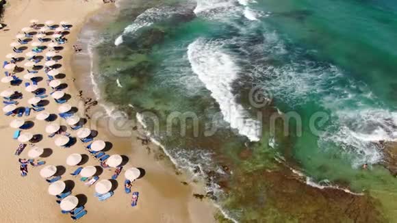 海滩世界著名的冲浪者的天堂装饰椅子和雨伞海滩上的游客海浪和海浪视频的预览图