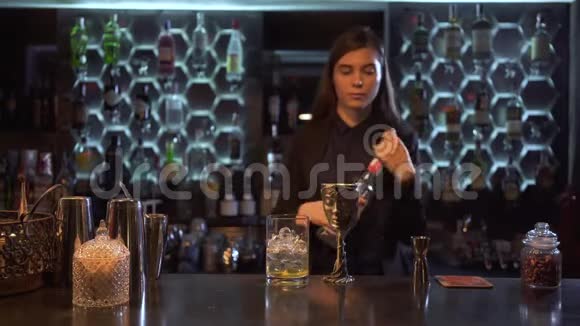 漂亮的女酒保站在酒吧里做了一杯好酒视频的预览图
