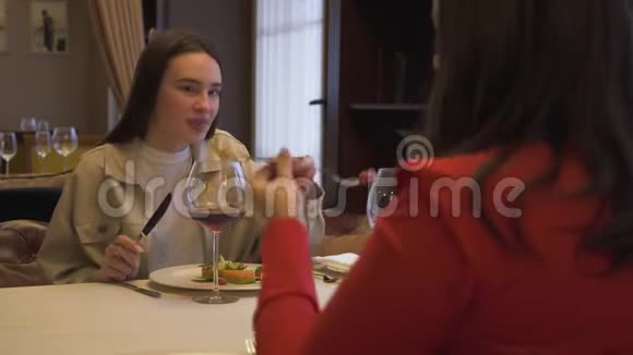 两个漂亮的女朋友坐在现代餐厅里在一起女孩在豪华餐厅品尝新菜视频的预览图