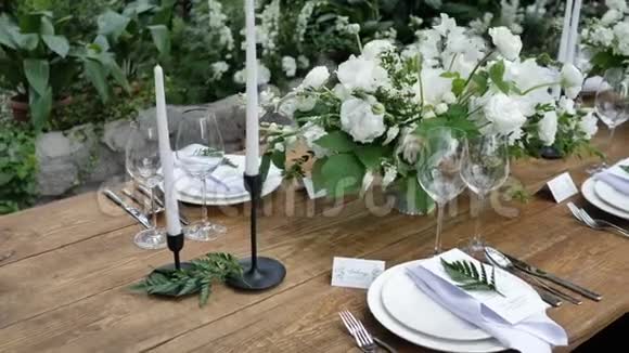 美丽的装饰一张古老的木制桌子用于一个乡村风格的婚礼晚会花束和蜡烛视频的预览图