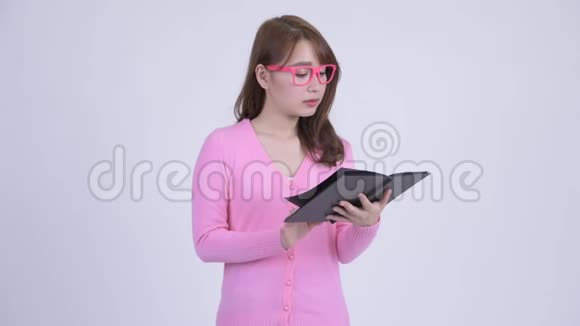 年轻的亚洲书呆子女人看书看起来很恶心视频的预览图