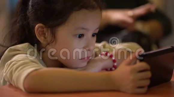 亚洲小中国女孩专注于看智能手机视频的预览图