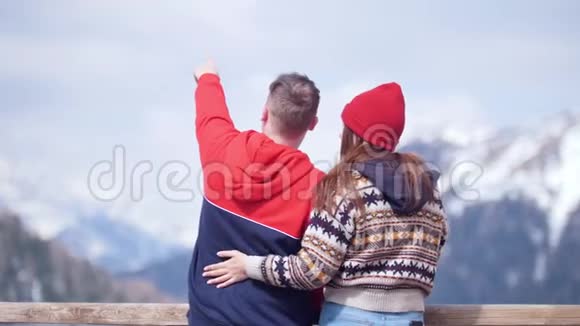 一对年轻夫妇站在群山的背景上享受风景拥抱视频的预览图