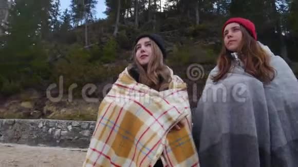 两个年轻的女人躺在毯子里看着山欣赏风景视频的预览图