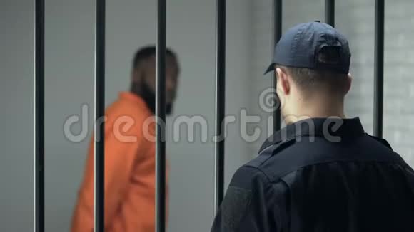 狱长看着在牢房里行走的危险罪犯无期徒刑监狱视频的预览图