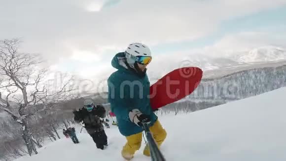 在阿拉斯加滑雪者在粉末日上山举着木板拍摄在戈普罗英雄8黑框架拍摄在一个视频的预览图