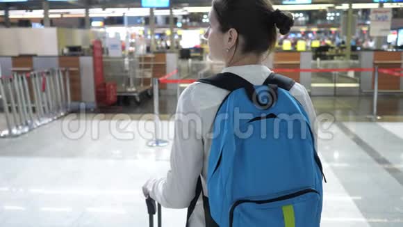 女士前往机场候机楼登记台后景视频的预览图