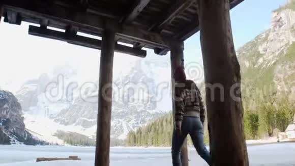 年轻漂亮的女人走在小屋下面的一条泻湖海岸上视频的预览图