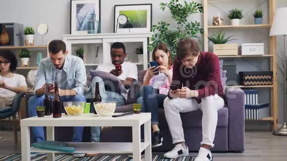 千禧一代在家使用智能手机享受社交媒体上网视频的预览图