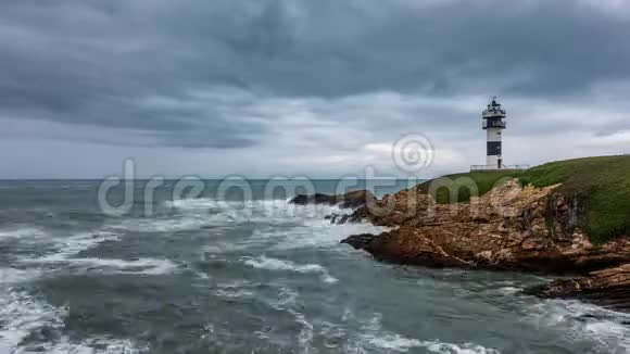 崎岖的海岸线在云景下灯塔时间流逝视频的预览图