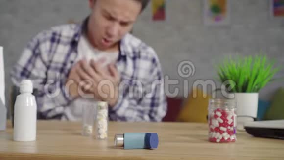 亚洲青年男子穿着一件带有窒息性发作的哮喘衬衫用吸入器猛烈射击视频的预览图
