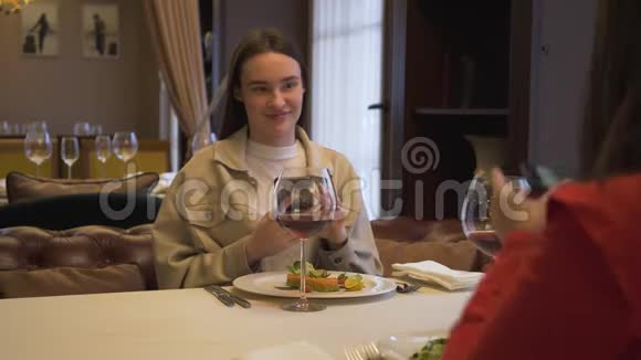 两个积极的女朋友坐在现代餐厅里在一起现代女性在食物中拍照视频的预览图