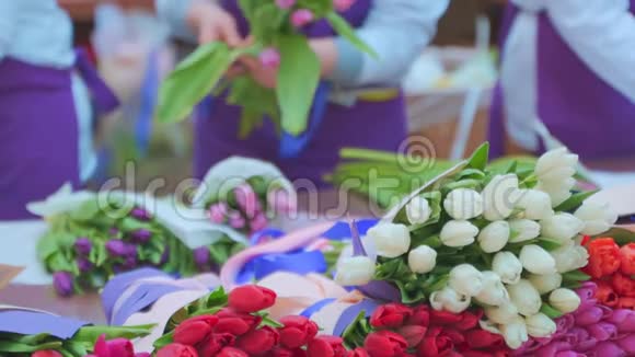 女花匠用包装工艺纸包裹着美丽的郁金香花束视频的预览图
