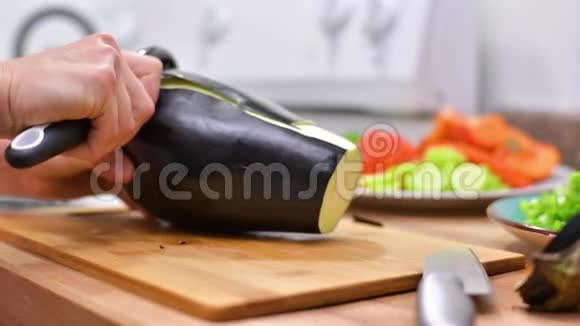 女人用菜刀在木板上切鲜茄子视频的预览图