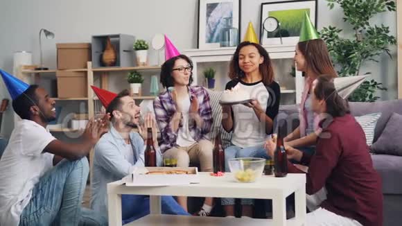 年轻人用蛋糕纸屑和派对哨子慢镜头庆祝生日视频的预览图