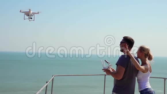 年轻的浪漫情侣演习与远程控制器在海上男人和女人追求空中自我视频的预览图