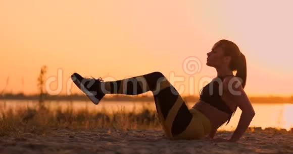 强壮的年轻女子在沙丘上做药球训练在沙漠进行健身训练时使用旋转运动的运动员视频的预览图
