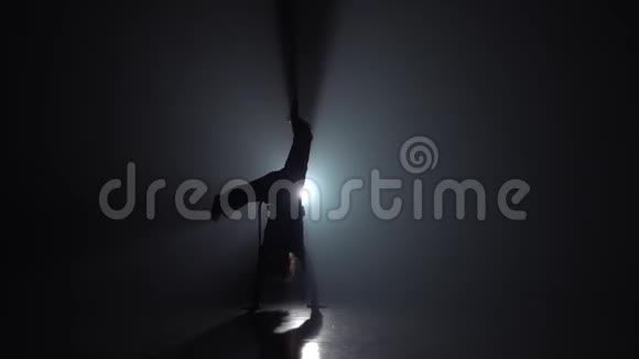 卡波伊拉一个在黑暗中面对灯光的卷曲女孩慢动作视频的预览图
