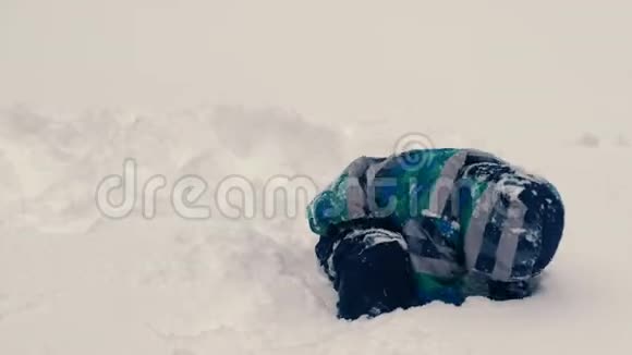 男孩在雪地上挖了个洞然后爬了进去视频的预览图