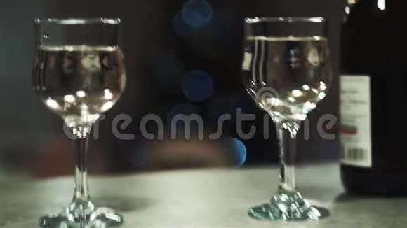 相机在2杯之间来回移动桌子上有一瓶香槟闪烁的灯光圣诞树视频的预览图