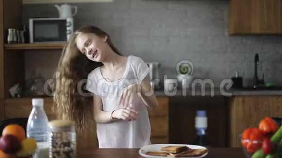 留着长发的可爱女孩在厨房跳舞视频的预览图