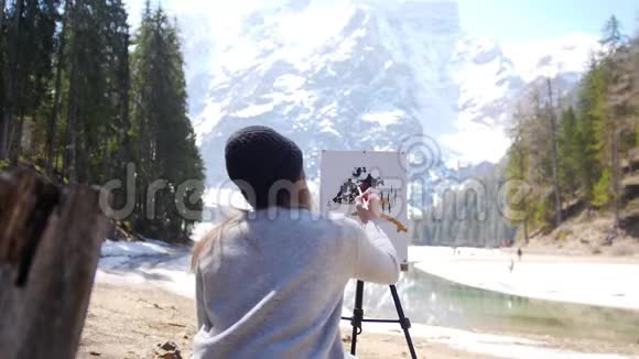 白云石一个年轻的女人画着被森林包围的山在画上添加颜色视频的预览图