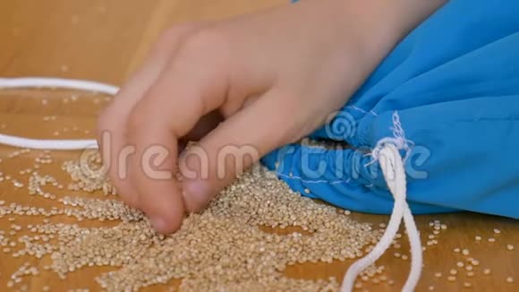 儿童手玩白色藜麦种子在蓝色可重复使用的包装在木制背景环保包装及健康视频的预览图