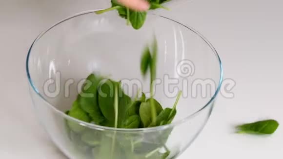 厨师把切碎的菠菜从木板上倒入玻璃碗里做蔬菜沙拉用视频的预览图