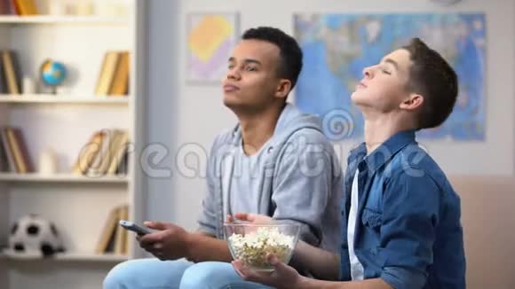 青少年在电视上看节目把爆米花扔到嘴里拖延症视频的预览图