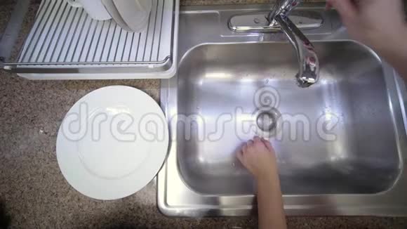 女人正在厨房的水槽里用自来水洗黄瓜视频的预览图