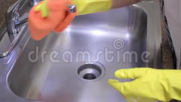 女人用橡胶手套用超细纤维毛巾清洗厨房水槽视频的预览图