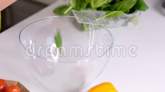 厨师把切碎的菠菜从木板上倒入玻璃碗里做蔬菜沙拉用视频的预览图