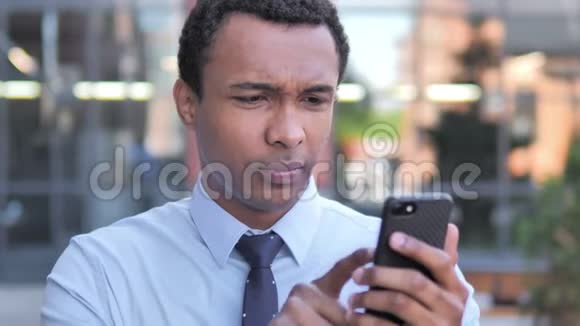 户外的非洲商人在使用智能手机时感到失落视频的预览图