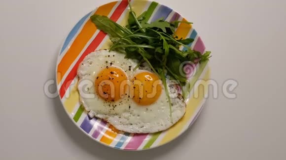 盘子里有两个煎蛋把盘子和煎蛋放在木桌上用煎蛋把白瓷盘合上视频的预览图