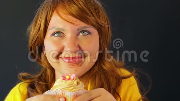 一个红发的年轻女人在节食之后脸上沾着巧克力色吃蛋糕却没人看见视频的预览图