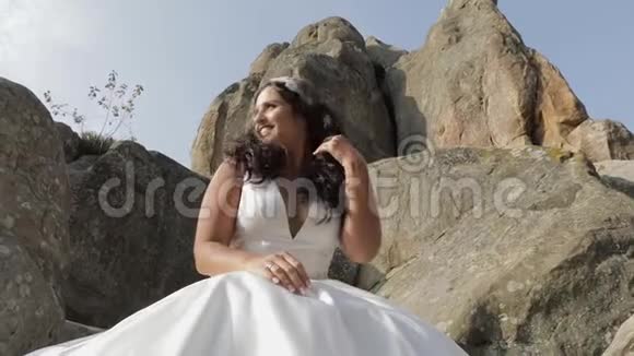 新娘坐在山的高坡上很开心跳舞和做脸视频的预览图
