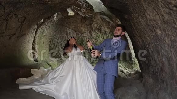 新婚夫妇新郎打开一瓶香槟慢动作视频的预览图