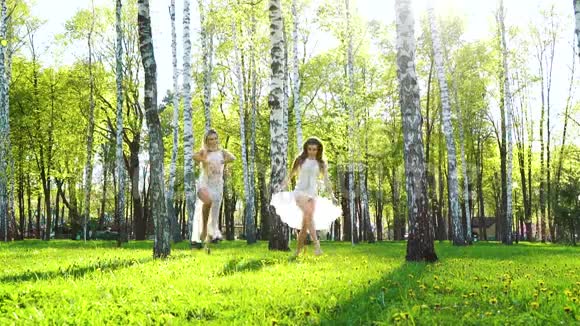两位身着性感服装的女舞者在阳光明媚的桦树林里表演视频的预览图