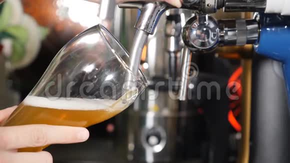 啤酒倒入和泡沫玻璃在黑色酒吧背景特写慢速运动把金啤酒倒进玻璃杯里视频的预览图