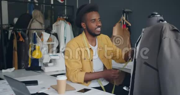 创意设计师测量假人的手工服装微笑着享受工作视频的预览图