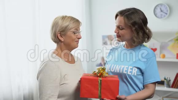 节日慈善会一位穿着t恤的快乐女士送给老太太礼物盒视频的预览图