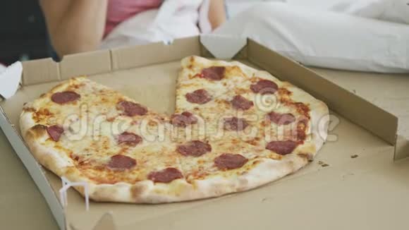 穿着工作服的微笑女人吃着美味的披萨视频的预览图