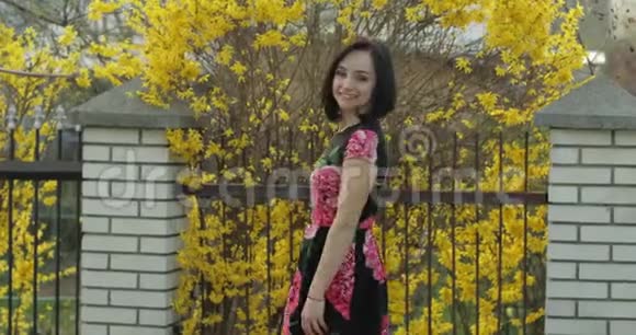 漂亮的年轻女人穿着一件带着花跳舞的裙子可爱的女孩视频的预览图