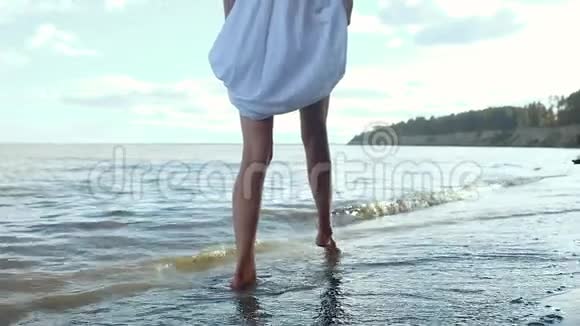年轻的模特长腿沿着海边沙滩散步旋转和大笑视频的预览图