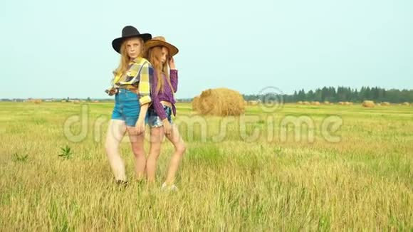 穿牛仔帽的女孩站在农村的田野上视频的预览图
