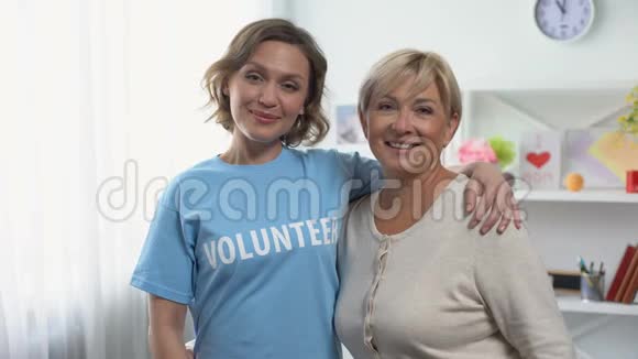 成年女性和年轻女性指着t恤上的志愿者碑文视频的预览图