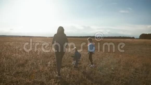 妈妈和两个孩子在球场上踢足球友好家庭观念视频的预览图